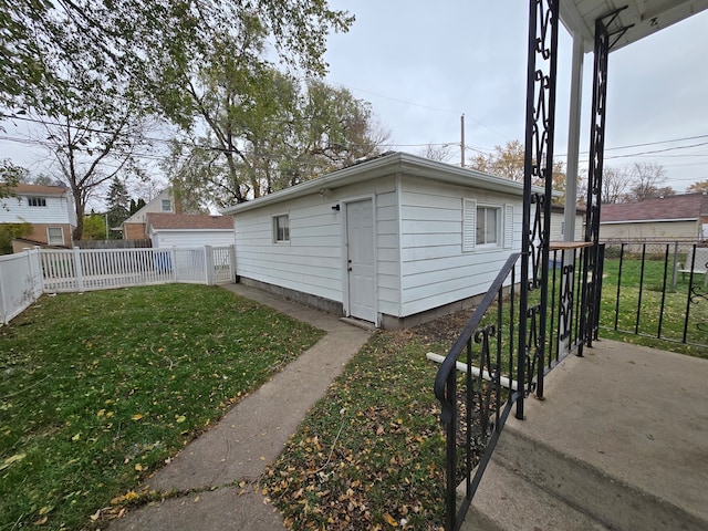 view of home's exterior featuring a lawn and an outdoor structure