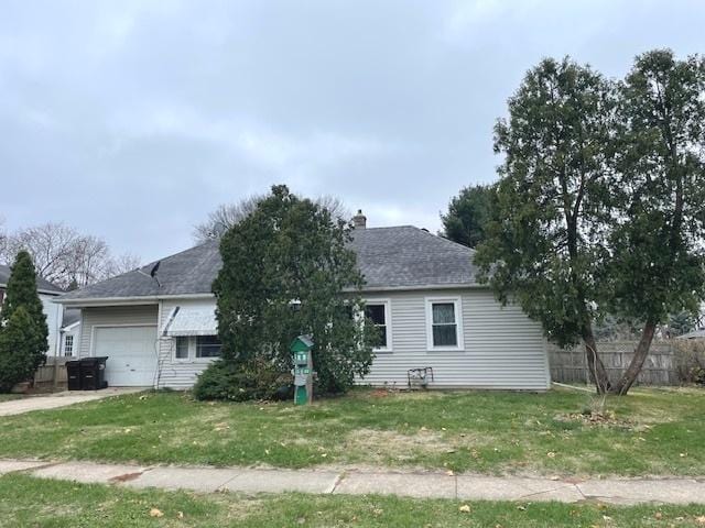 exterior space featuring a garage and a lawn