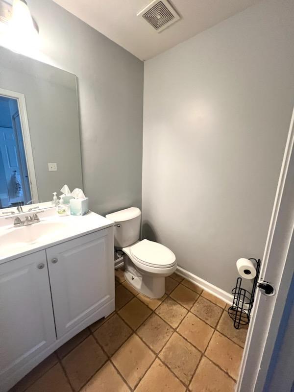 bathroom with tile patterned flooring, vanity, and toilet