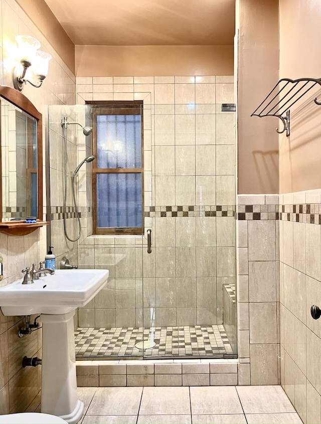 bathroom featuring a shower with door, tile patterned floors, and tile walls