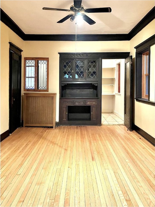 unfurnished living room with ceiling fan, ornamental molding, and light hardwood / wood-style flooring