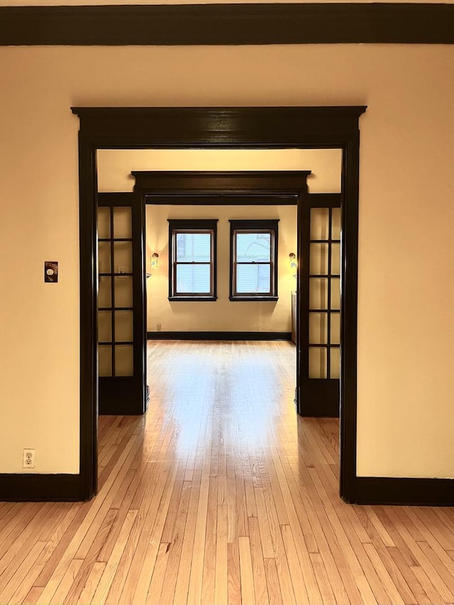 hallway with french doors and light wood-type flooring