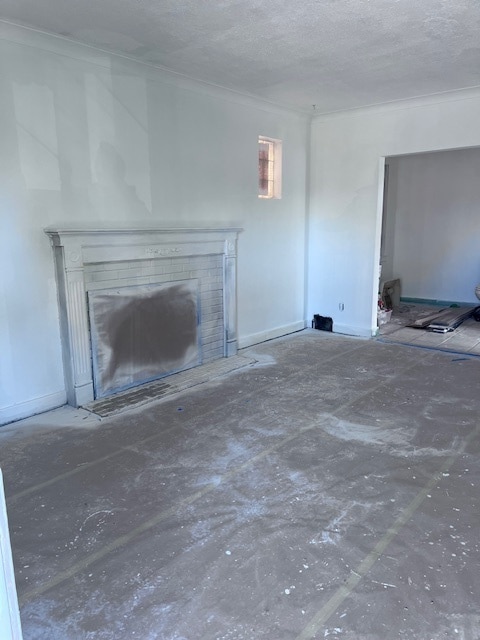 unfurnished living room featuring a textured ceiling and a brick fireplace