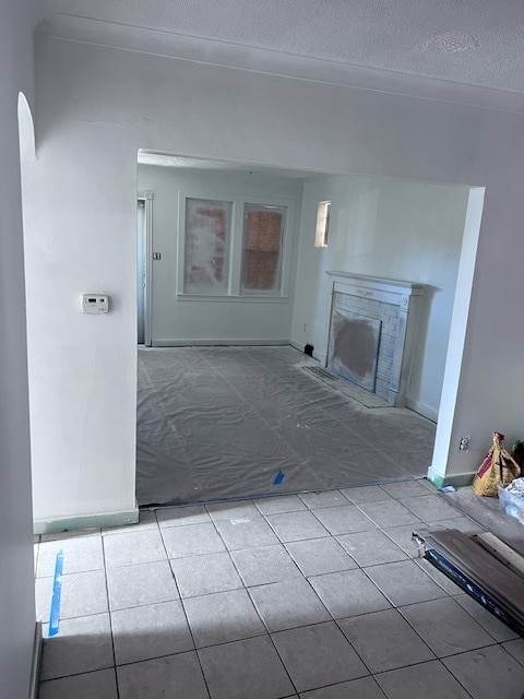 unfurnished living room with light tile patterned floors and a textured ceiling