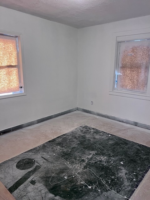 unfurnished room with a textured ceiling