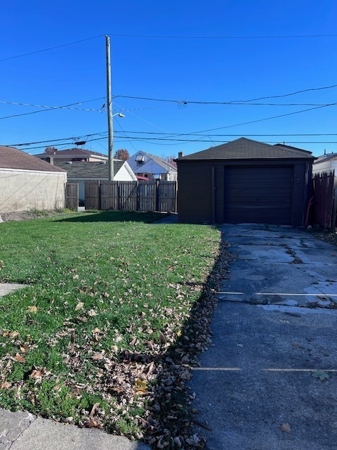 view of yard featuring a garage and an outdoor structure