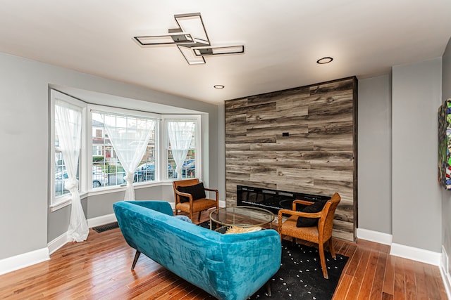 living area featuring a tile fireplace and wood-type flooring