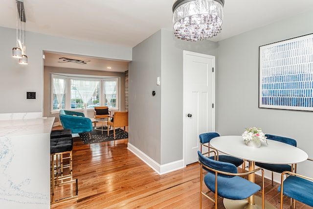 dining space featuring wood-type flooring and a chandelier