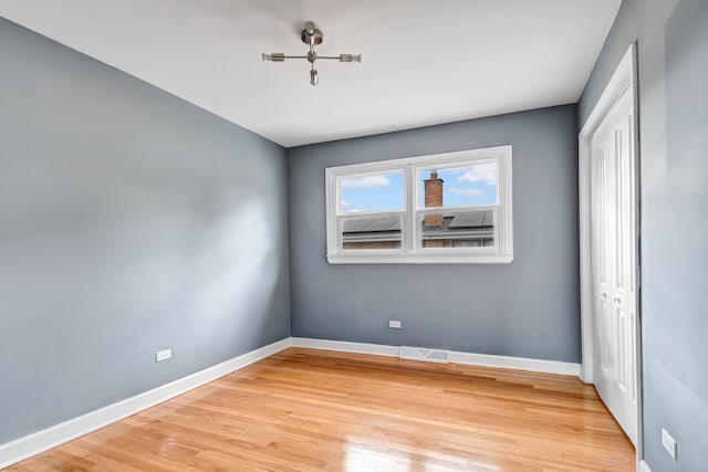 unfurnished bedroom with light wood-type flooring and a closet