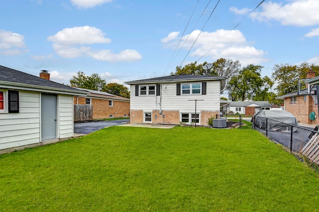 back of property with a yard and central air condition unit