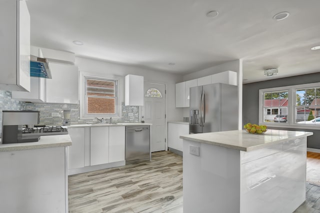 kitchen featuring white cabinets, light wood-type flooring, a center island, and stainless steel appliances