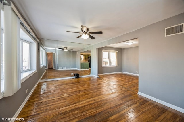 empty room with ceiling fan and dark wood-type flooring