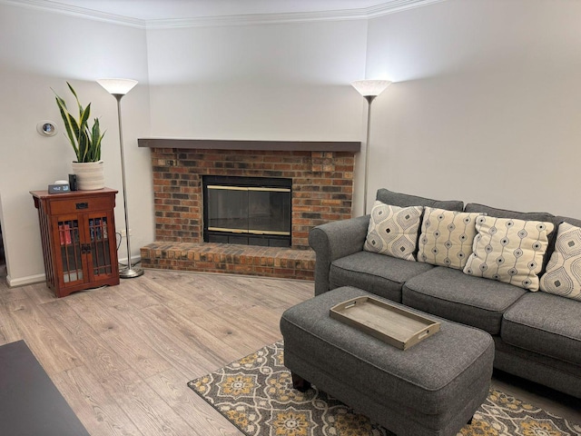 living room featuring ornamental molding, a fireplace, and light hardwood / wood-style flooring