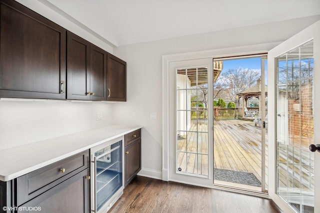 entryway with indoor bar, beverage cooler, and dark wood-type flooring