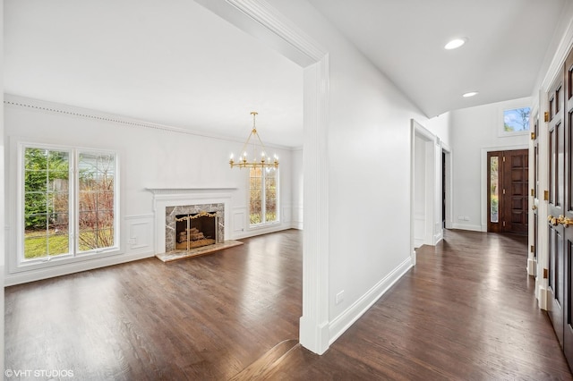 hallway with dark hardwood / wood-style floors, ornamental molding, and a wealth of natural light