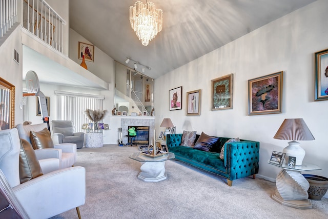 living room with carpet, a towering ceiling, rail lighting, and a chandelier