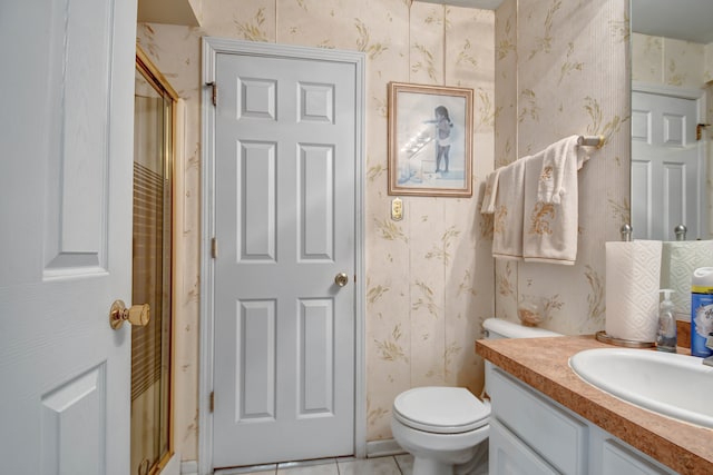 bathroom with tile patterned flooring, vanity, toilet, and walk in shower