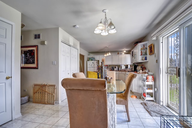 dining space featuring a notable chandelier and light tile patterned flooring