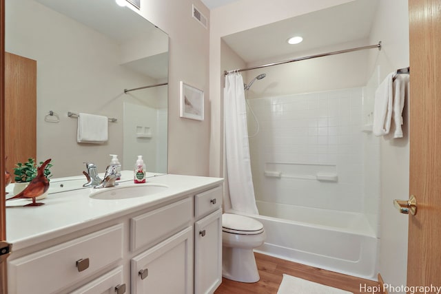 full bath featuring visible vents, toilet, wood finished floors, shower / bath combination with curtain, and vanity