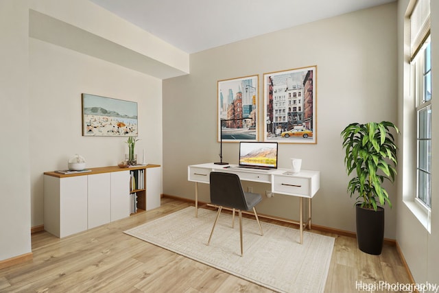 office area with baseboards and light wood-style flooring