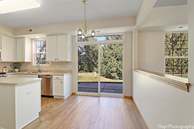 kitchen featuring stainless steel dishwasher, white cabinets, light wood finished floors, and a sink