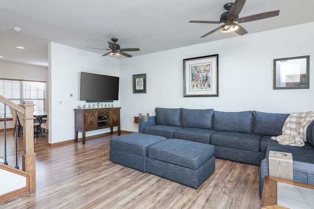 living room featuring wood-type flooring and ceiling fan