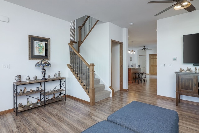 staircase with hardwood / wood-style floors and ceiling fan