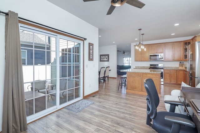 interior space featuring ceiling fan with notable chandelier and light wood-type flooring