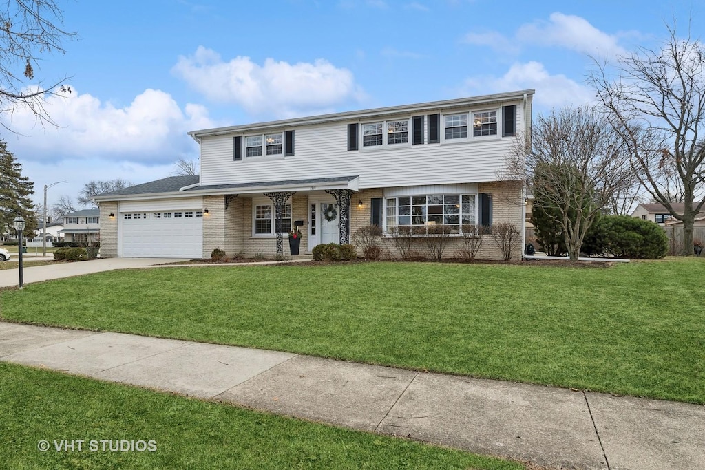 view of front of home with a front yard, a porch, and a garage