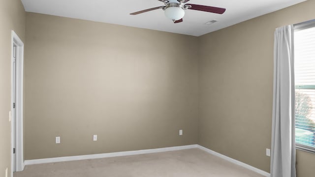 empty room featuring ceiling fan and light carpet