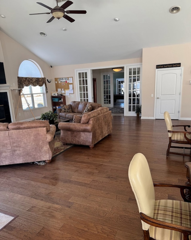 living room with ceiling fan, a fireplace, dark wood-type flooring, and vaulted ceiling