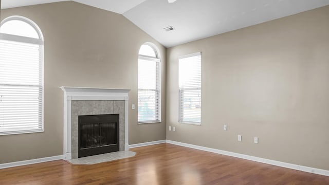 unfurnished living room with hardwood / wood-style floors, lofted ceiling, and a fireplace