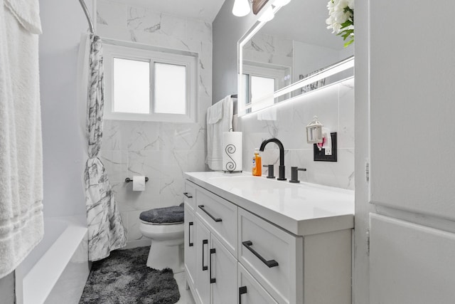 full bathroom featuring shower / tub combo with curtain, vanity, tile walls, and toilet