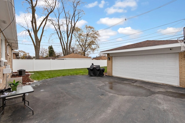 garage featuring a lawn and central AC