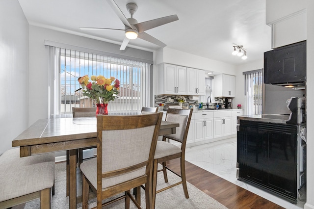 dining space featuring ceiling fan, light hardwood / wood-style flooring, and sink