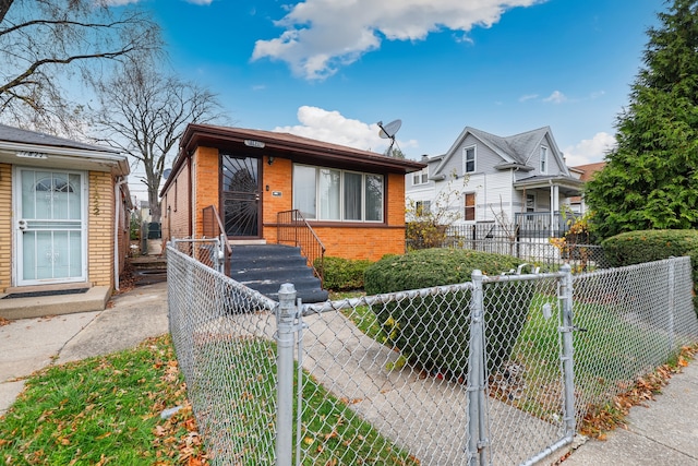 bungalow-style house featuring a fenced front yard and brick siding