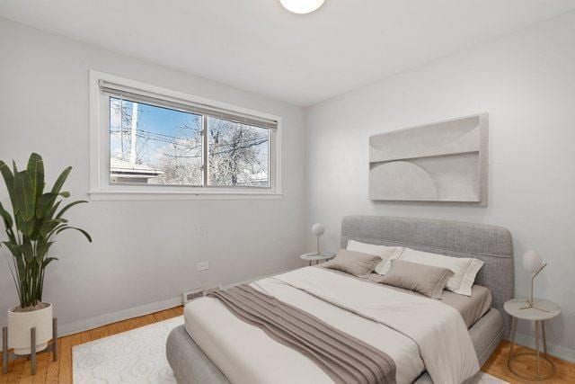 bedroom with baseboards and wood finished floors