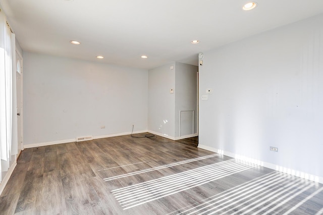 spare room with recessed lighting, visible vents, baseboards, and wood finished floors