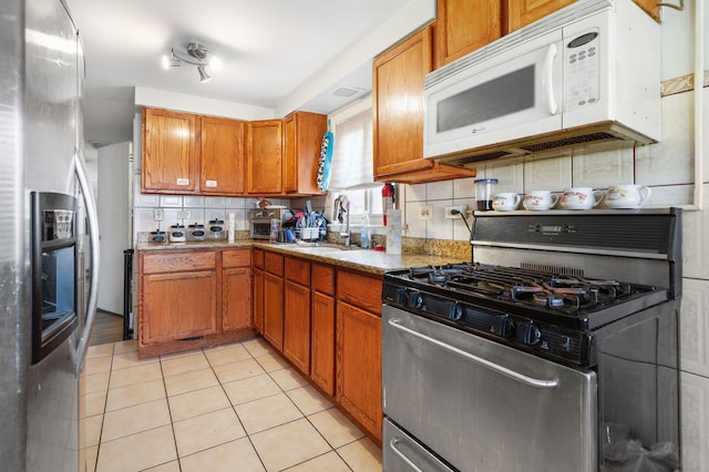 kitchen featuring decorative backsplash, light tile patterned flooring, sink, and stainless steel appliances