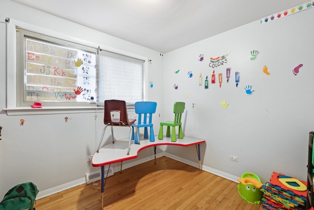 rec room with light hardwood / wood-style flooring