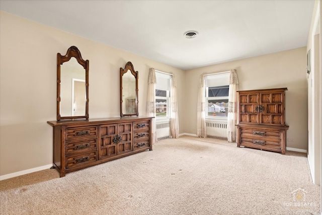 bedroom featuring light colored carpet and radiator