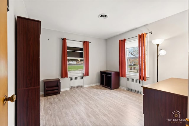 interior space with light hardwood / wood-style flooring and radiator