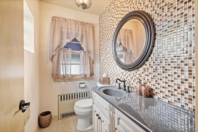 bathroom with vanity, radiator, tile patterned flooring, toilet, and tasteful backsplash