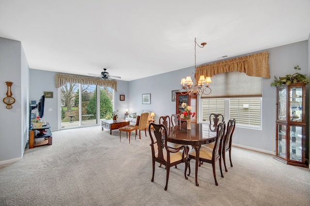 carpeted dining area featuring ceiling fan with notable chandelier