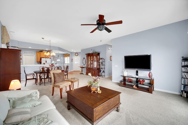 living room with ceiling fan with notable chandelier and light colored carpet