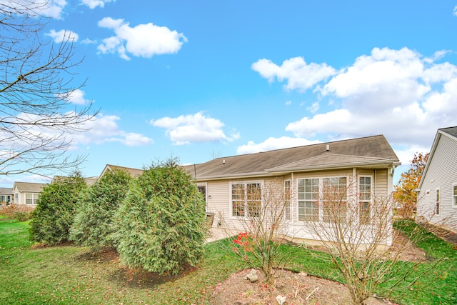 back of property with a patio area and a lawn