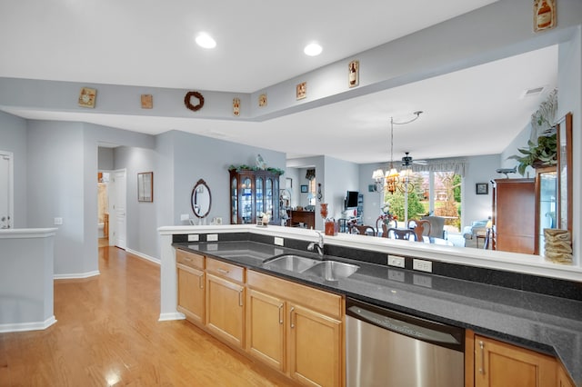 kitchen featuring dark stone counters, sink, stainless steel dishwasher, light hardwood / wood-style floors, and a chandelier