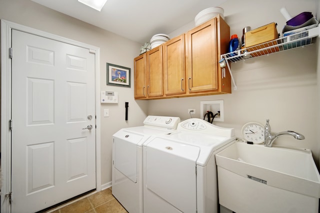 laundry room with washing machine and dryer, sink, light tile patterned floors, and cabinets