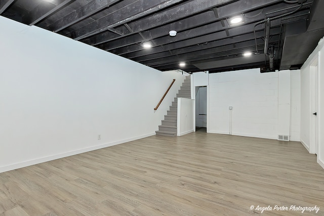 basement with light hardwood / wood-style flooring