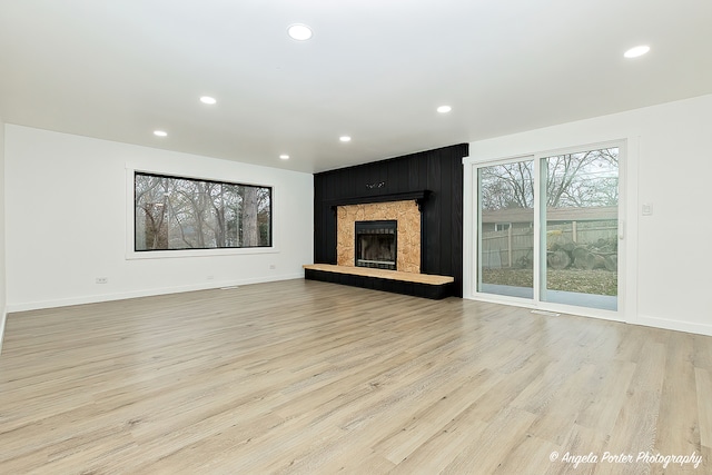 unfurnished living room with a fireplace and light hardwood / wood-style flooring